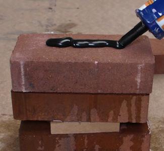 applying brick adhesive on brick